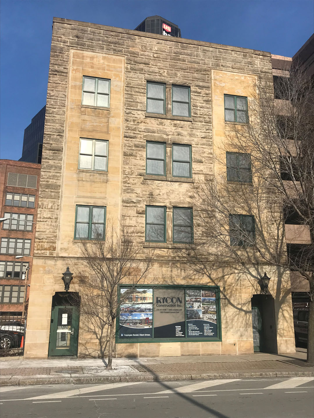 A four-story stone building with a Rycon Construction Inc. sign on the ground floor.