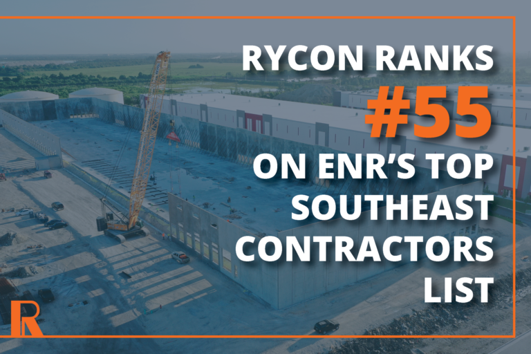 Aerial view of a large warehouse construction site with a yellow crane, overlaid with text: “Rycon ranks #55 on ENR’s Top Southeast Contractors list.”