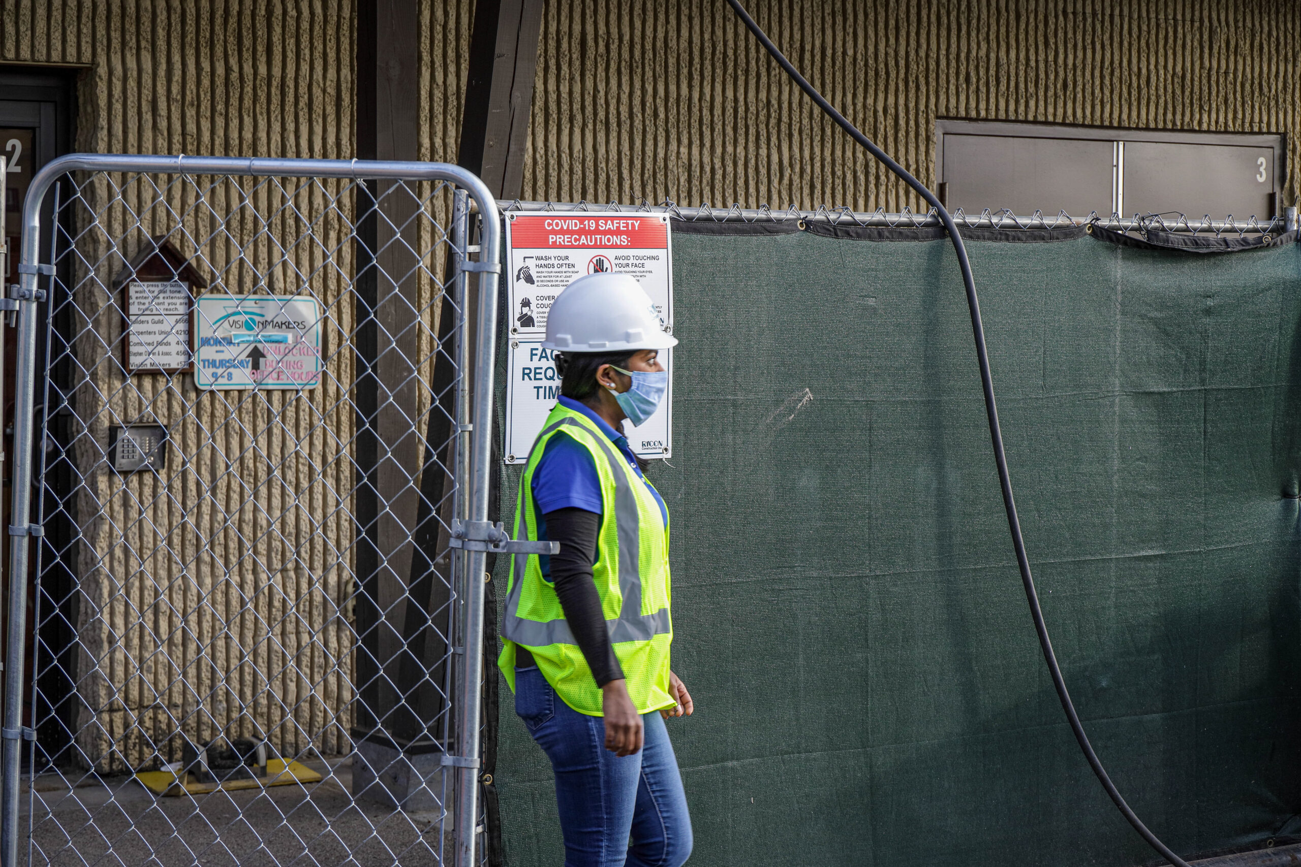 An array of gray electrical panels and conduit mounted on a concrete block wall inside an industrial room.