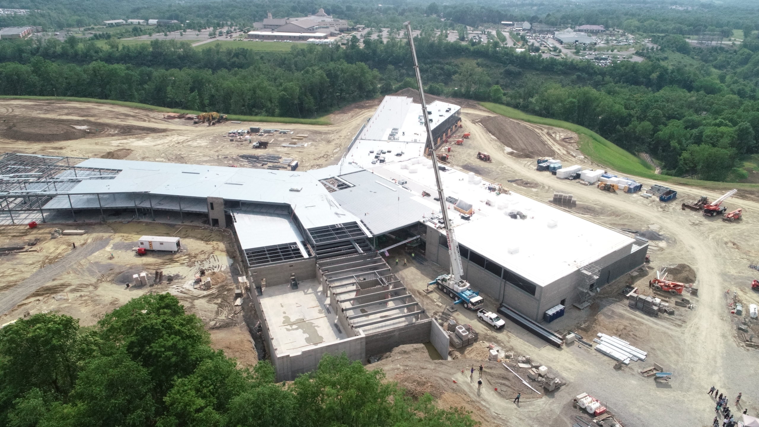 Aerial view of a large commercial building under construction with a crane on site.