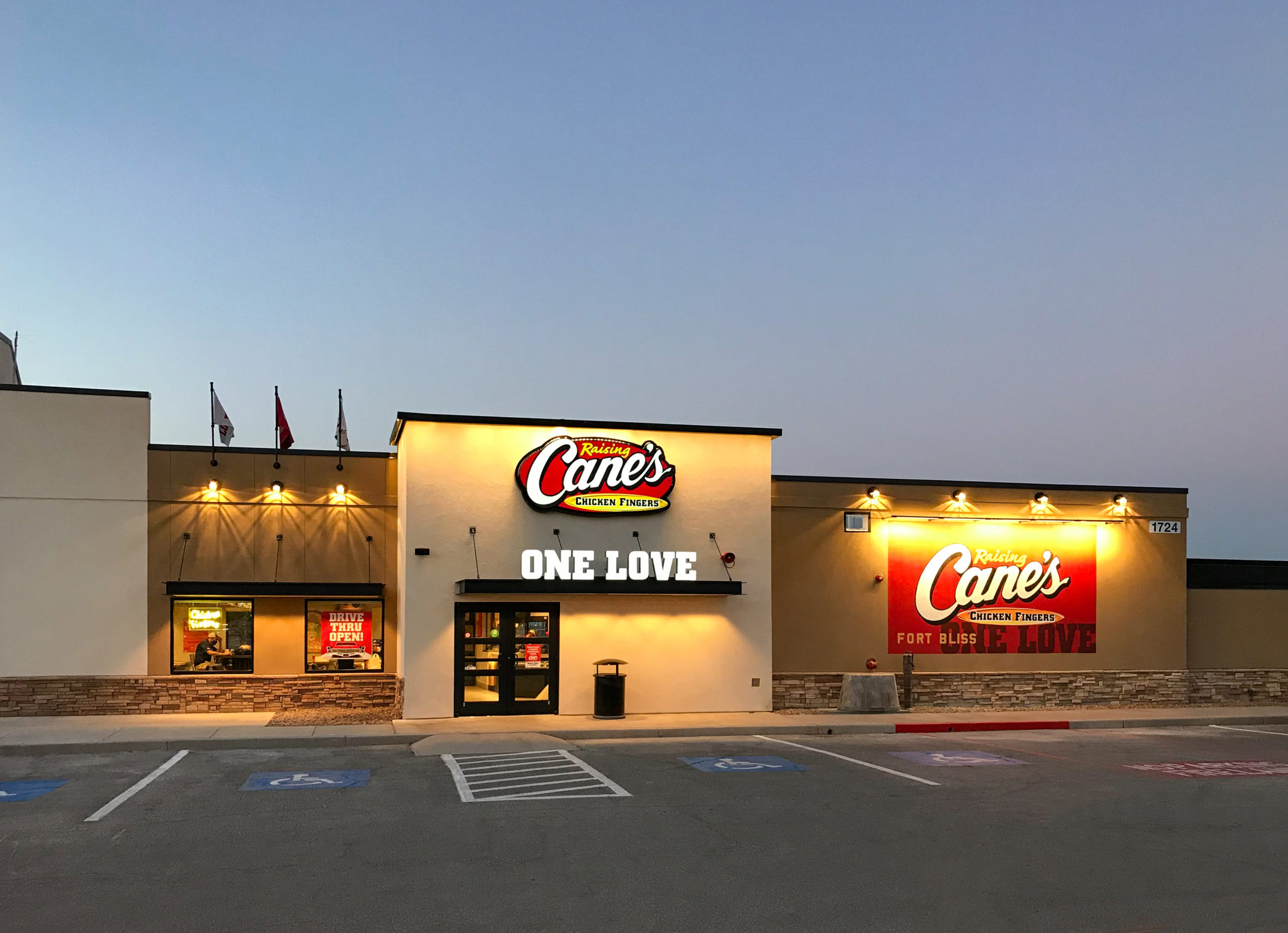 Raising Cane’s restaurant building with a drive-thru and parking lot.