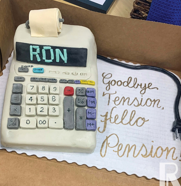 A cake shaped like a printing calculator with “RON” on the display, beside text written on the cake board that reads, “Goodbye Tension, hello Pension.”