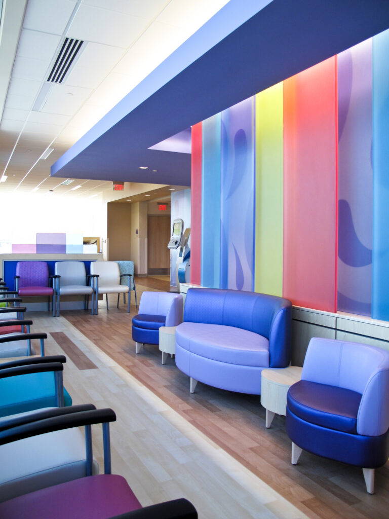 A modern waiting room featuring colorful walls and an array of purple and blue chairs.