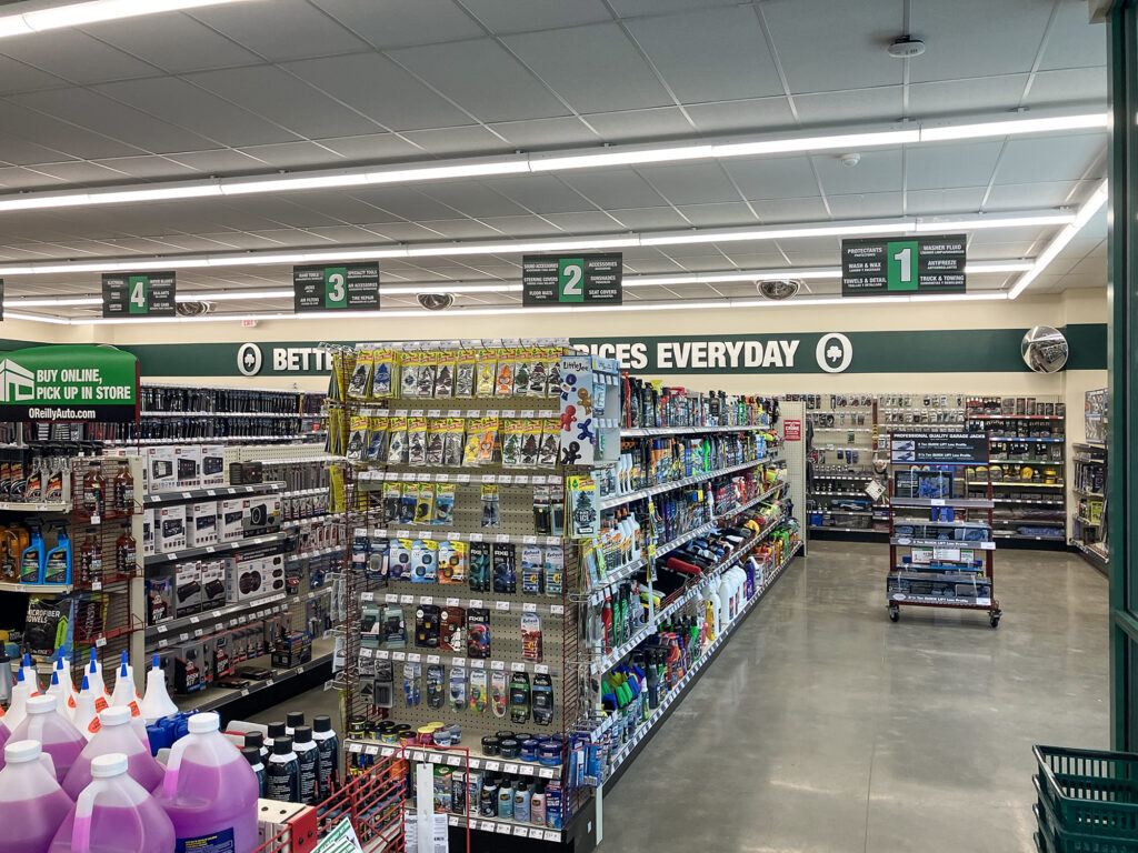 Interior of an O’Reilly Auto Parts store, showing aisles of automotive supplies and numbered aisle signs hanging from the ceiling.
