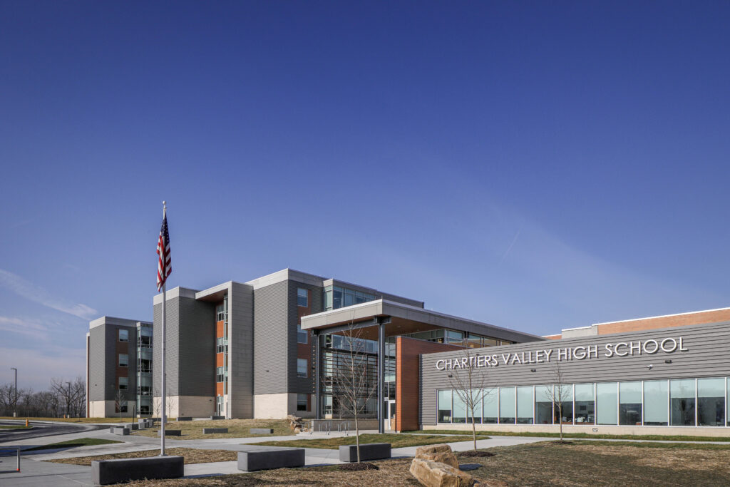 The exterior of Chartiers Valley High School under a clear blue sky, with the school name visible on the building facade.