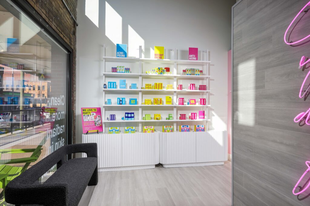 Shelves of skincare products organized by concern with signage for Acne-Prone, Brightening, and Anti-Aging lines.