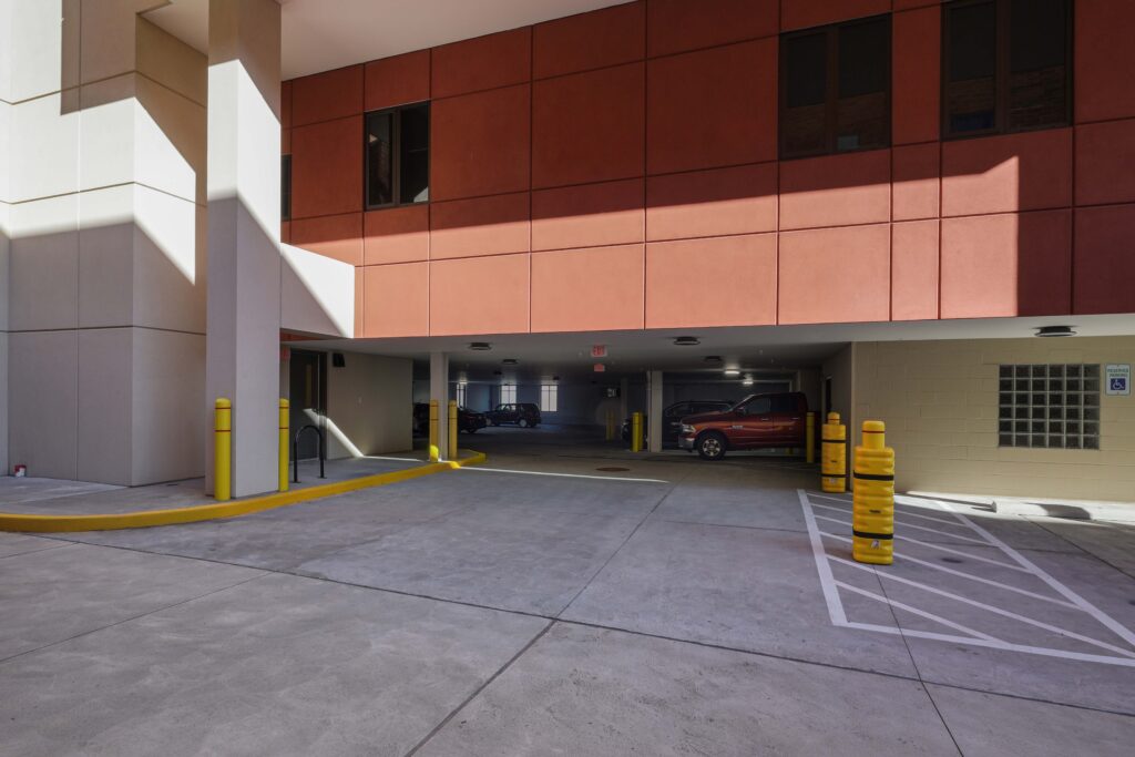 Entrance to a parking garage with a red truck and yellow safety bollards.