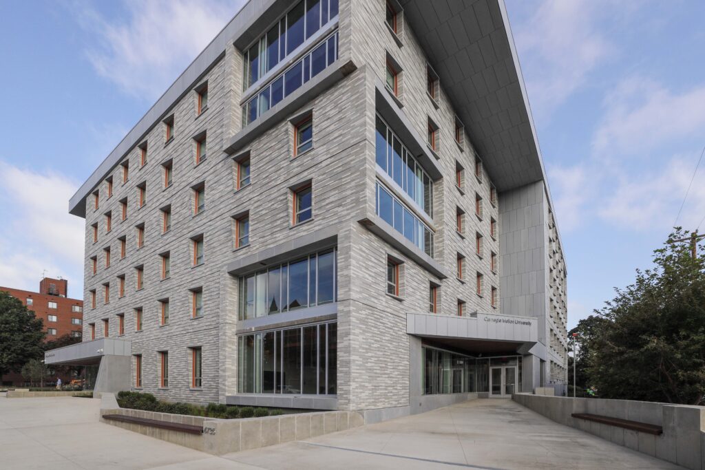Modern gray brick building on the Carnegie Mellon University campus with a large, cantilevered roof.