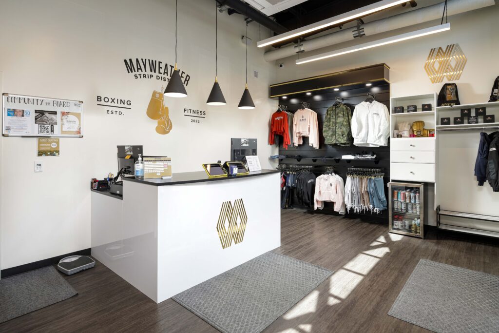 Front desk and retail clothing display inside a Mayweather Boxing + Fitness studio.