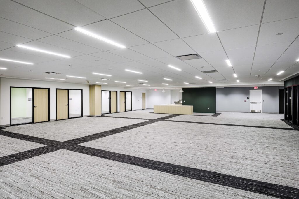 An empty, carpeted office space with multiple doorways and a central reception desk.