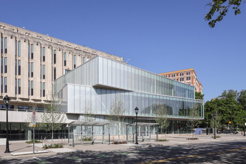 Exterior view of the Hillman Library, featuring a modern glass addition attached to a brutalist concrete building.