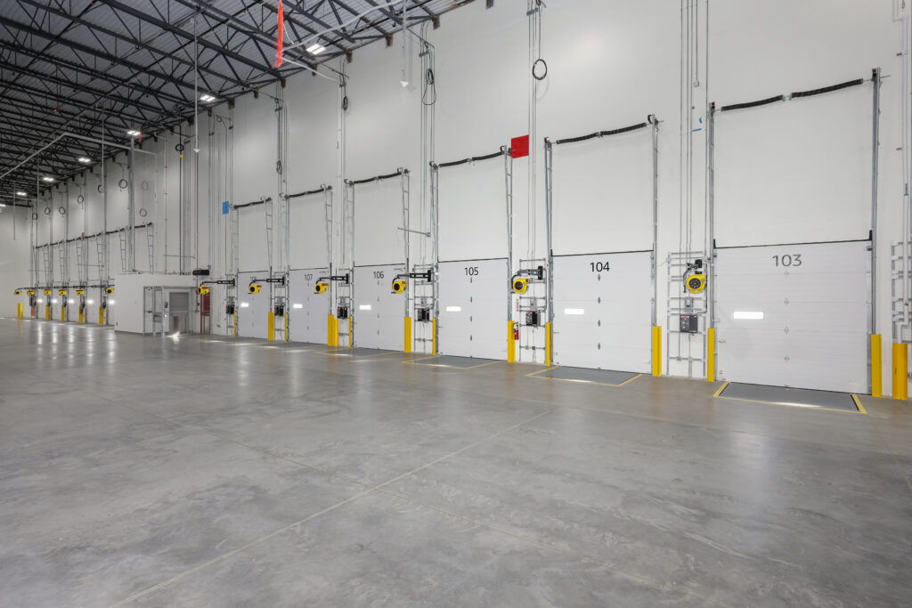 A line of numbered loading dock bays inside a large industrial warehouse.
