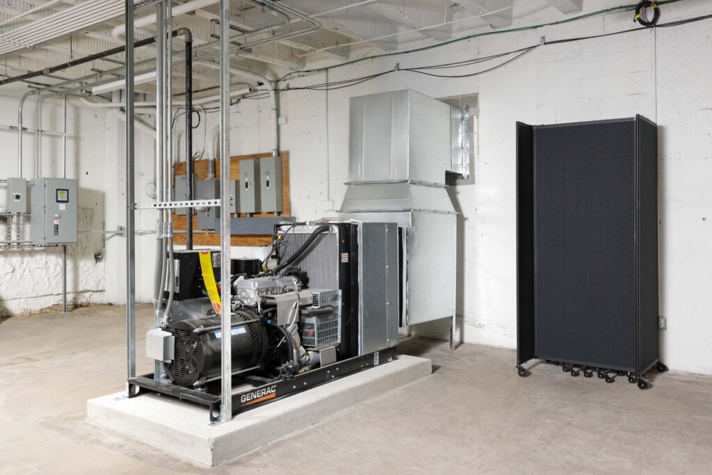 Generac industrial generator installed on a concrete pad in a utility room.