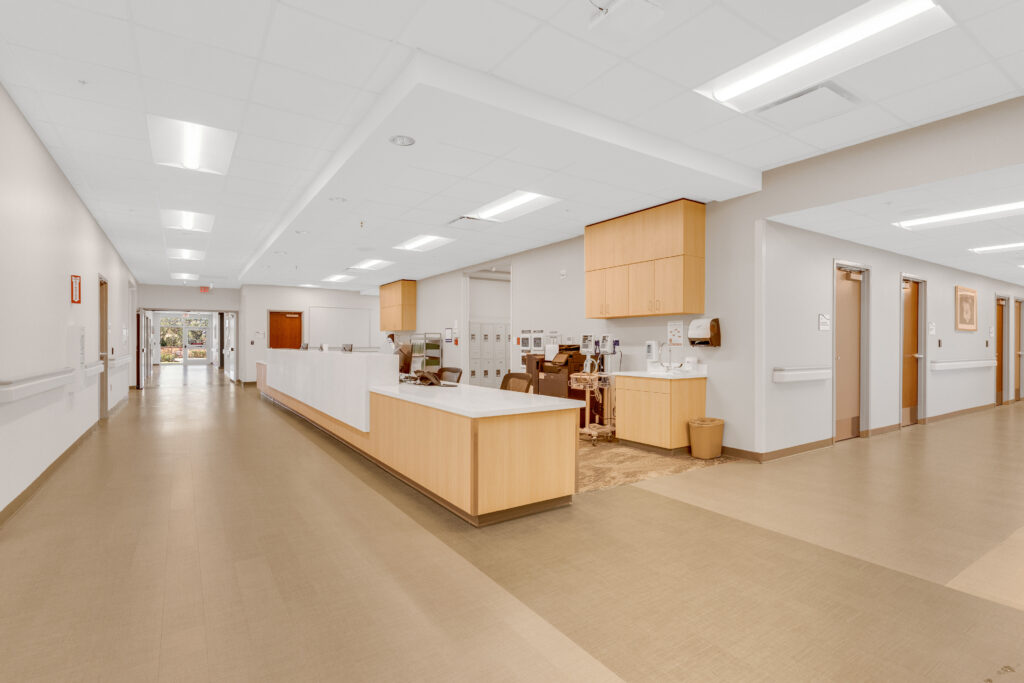 A reception desk in a brightly lit medical office hallway.