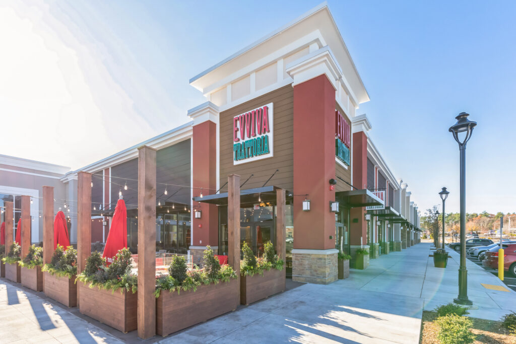 Exterior view of Evviva Trattoria restaurant with an outdoor dining patio and storefront signage.