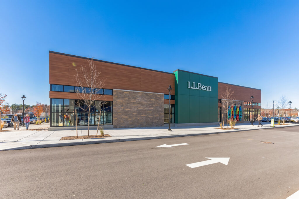 Exterior of an L.L.Bean retail store with wood-paneled and stone walls on a sunny day.
