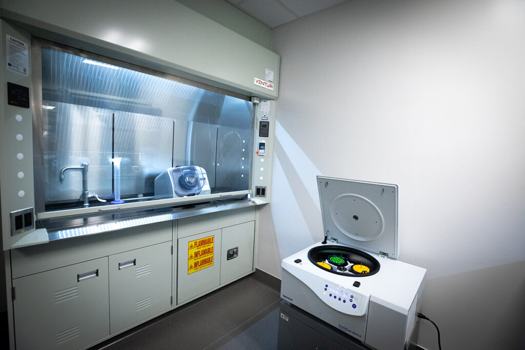 Laboratory fume hood with a centrifuge standing to the right.