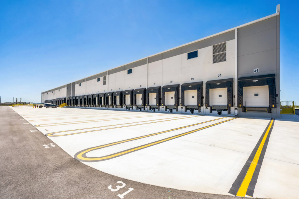 A long warehouse exterior with a row of numbered loading docks and bays.