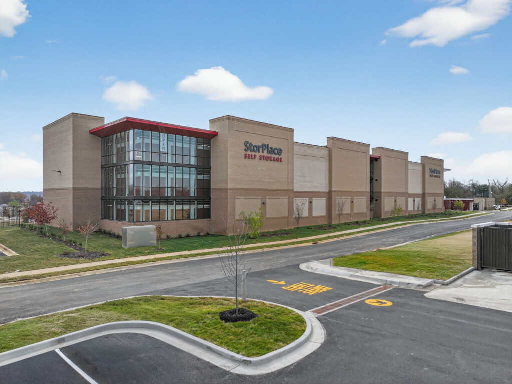 StorPlace Self Storage facility building with a tan brick exterior and glass corner entrance.