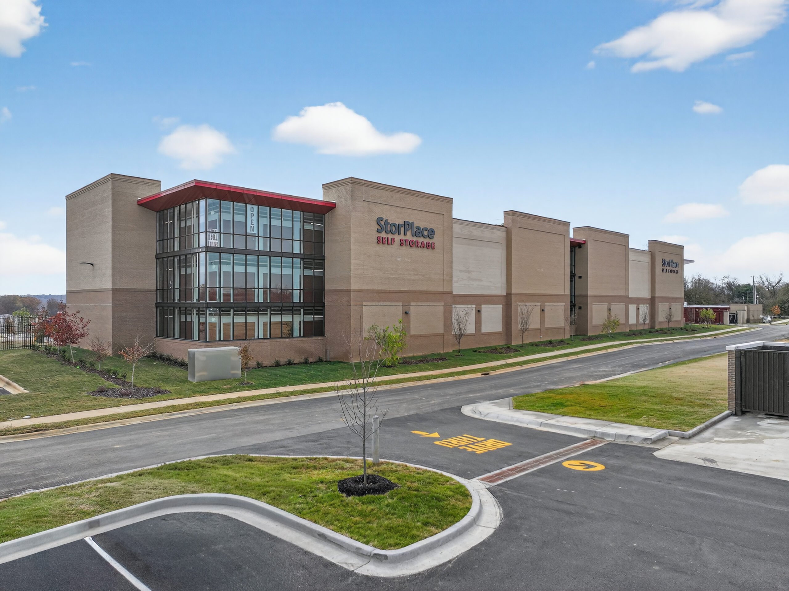 StorPlace Self Storage facility building with a tan brick exterior and glass corner entrance.