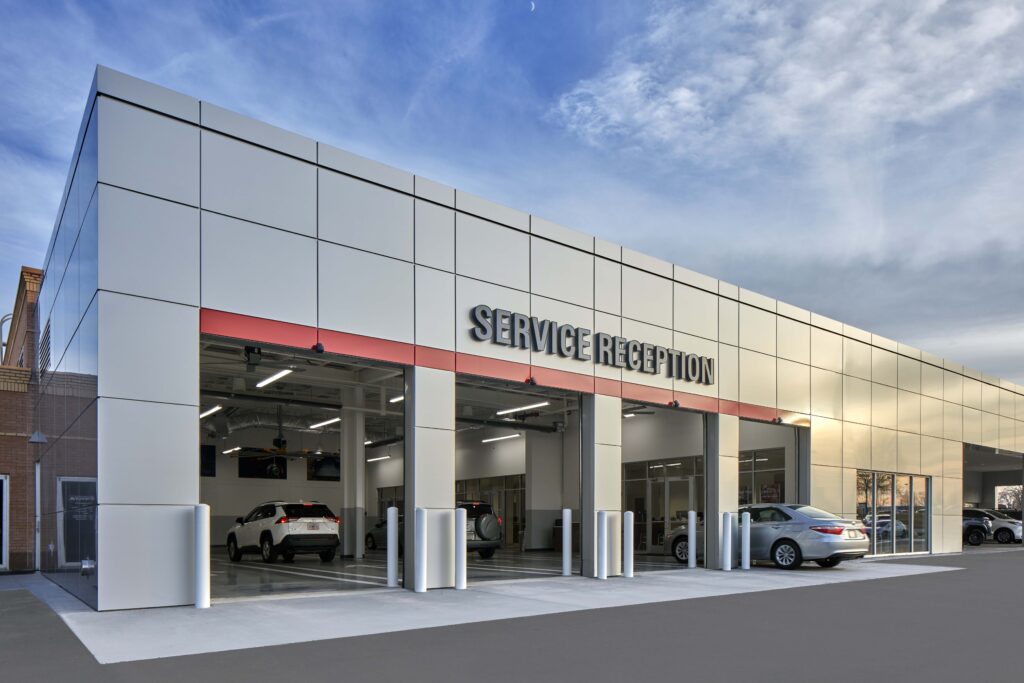 Exterior of an automotive service reception center with multiple drive-in bays.