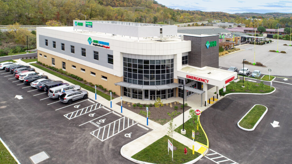 Aerial view of the AHN Harmar Neighborhood Hospital building with a parking lot and emergency entrance.