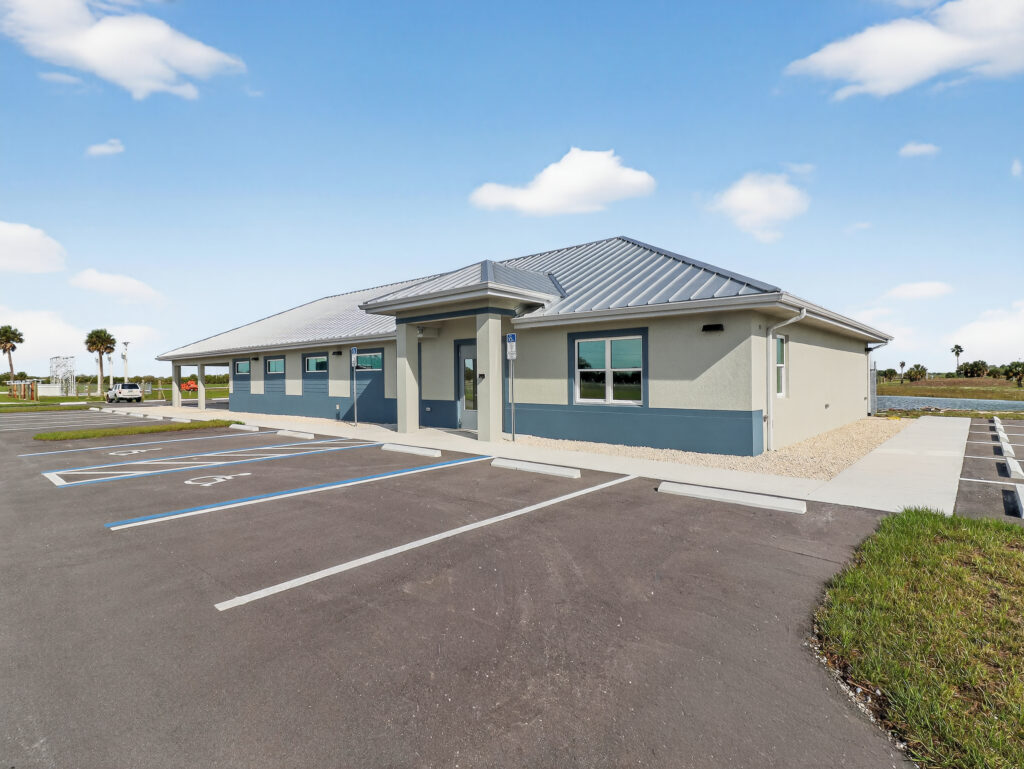 A single-story commercial building with a metal roof and a parking lot with designated accessible spaces in the foreground.