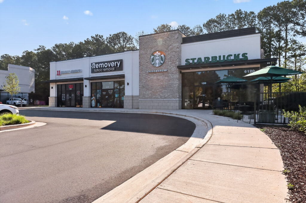 Exterior view of a shopping plaza with Jimmy John’s, Removery tattoo removal, and a Starbucks with a drive-thru.