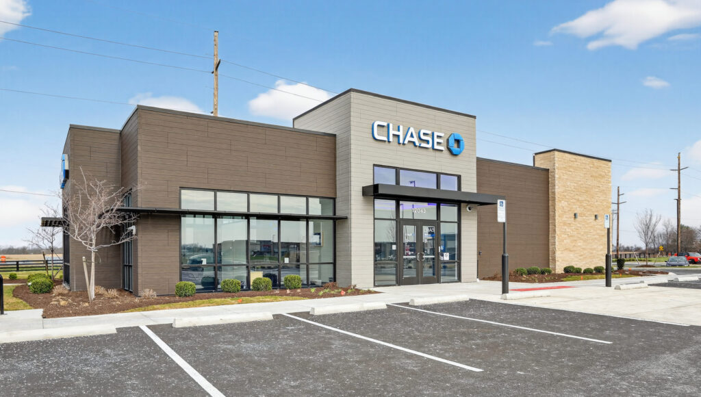 Exterior of a Chase bank branch with a parking lot in the foreground.