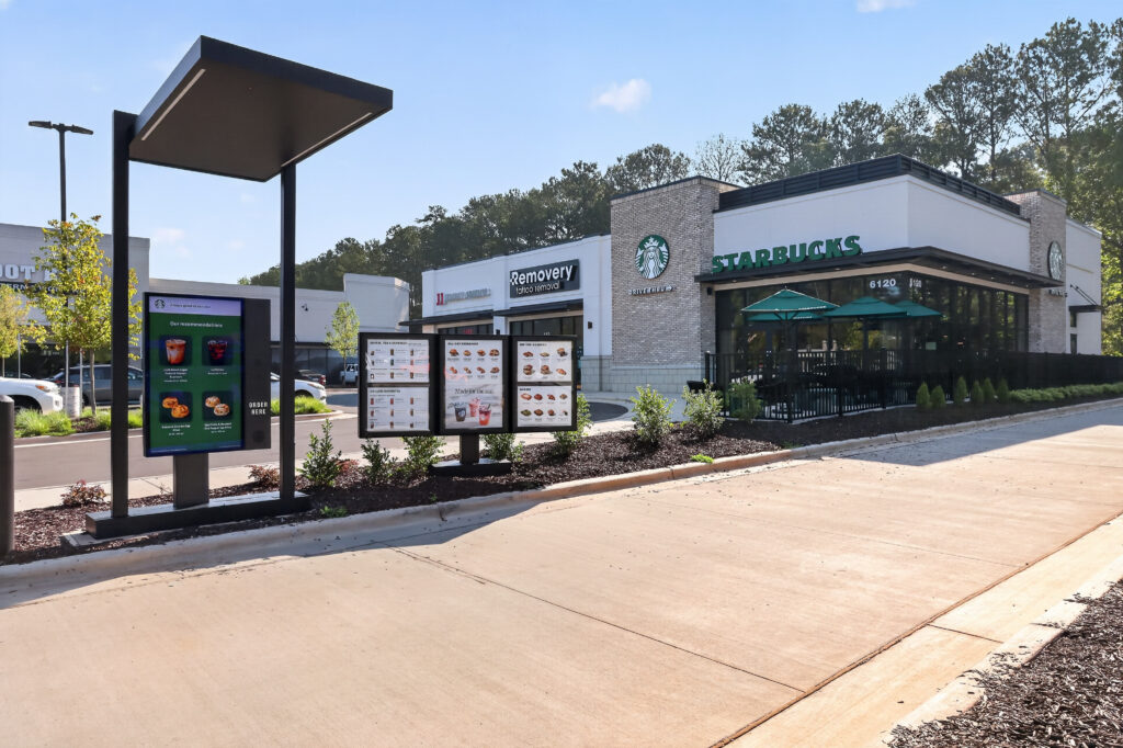 Starbucks drive-thru lane with a digital menu board in the foreground.