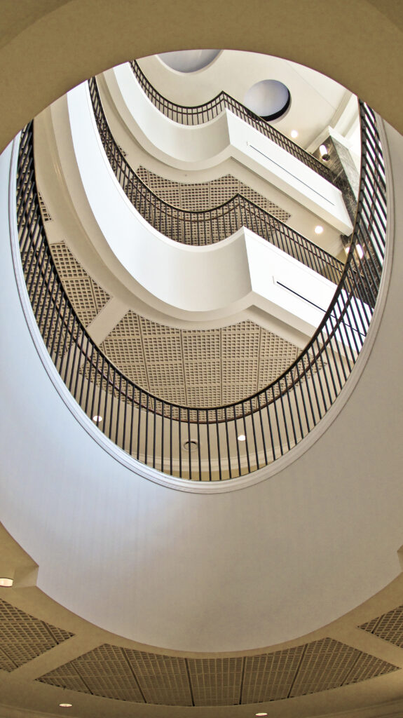 A spiraling staircase with dark railings, viewed from directly below.