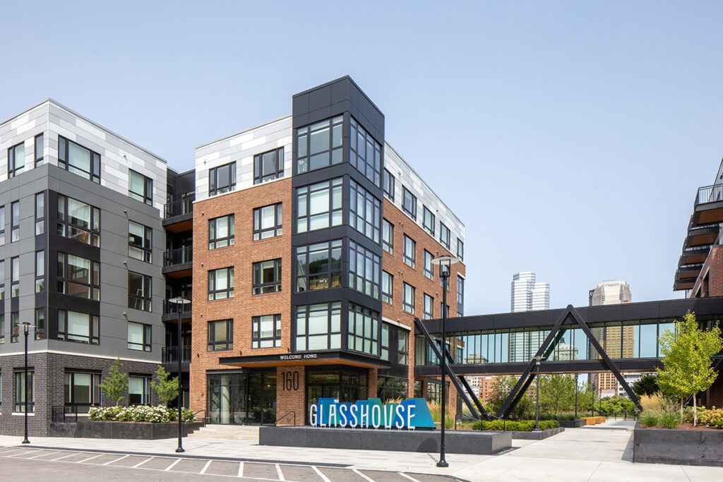 Modern apartment building labeled “Glasshouse” with a skybridge connecting two structures.