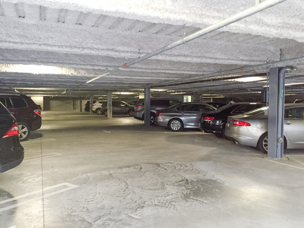 Cars parked in an indoor concrete parking garage.