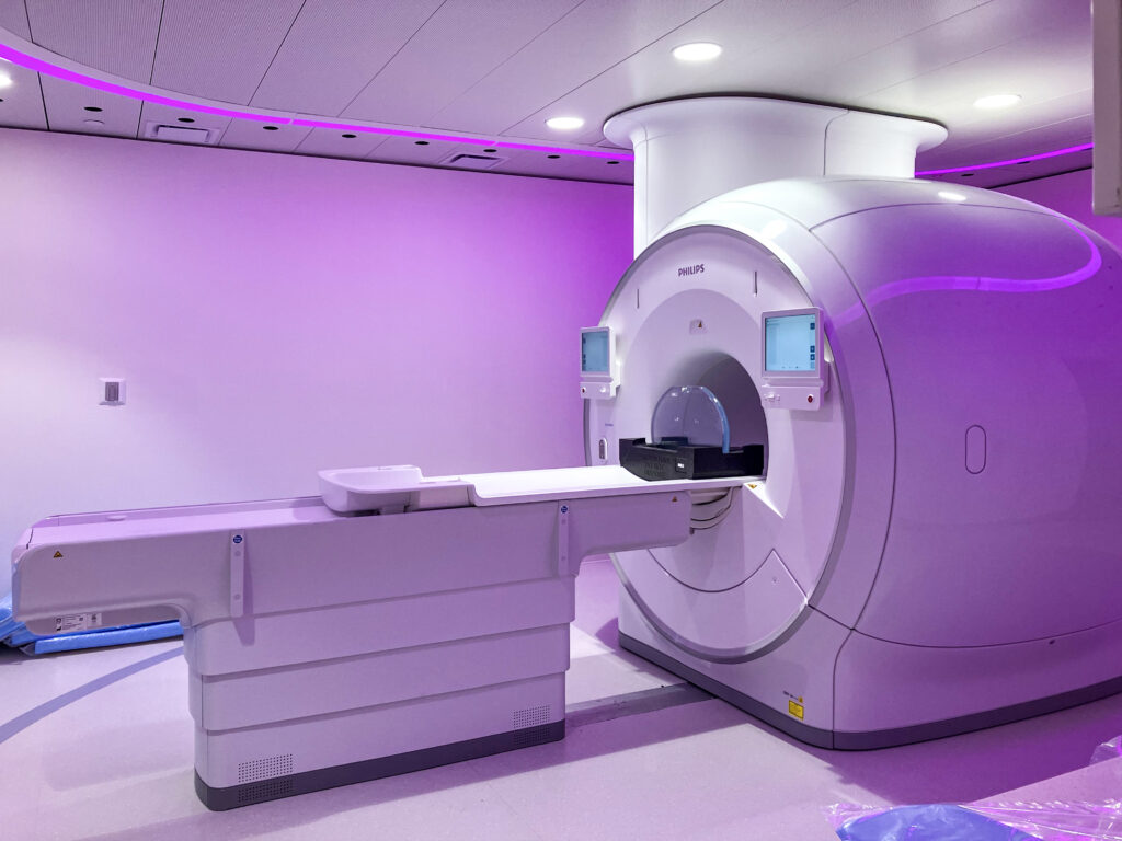 A Philips MRI scanner in a room with purple ambient lighting.