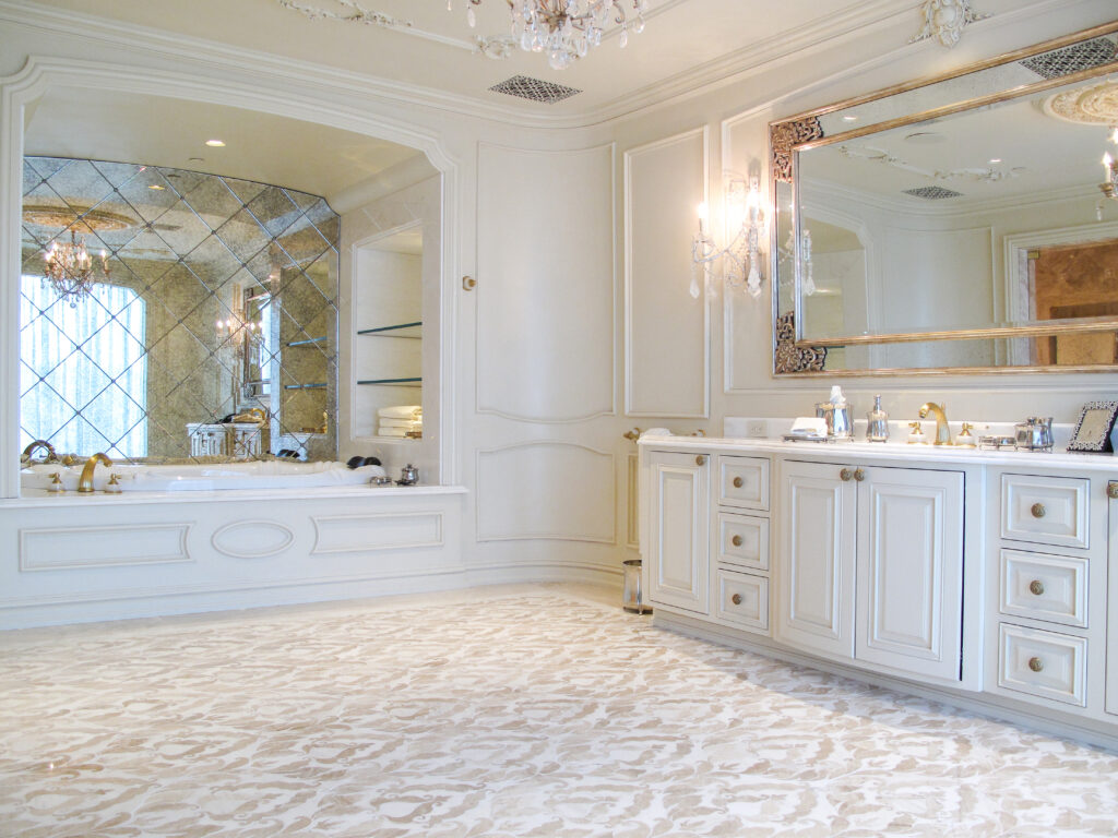 Luxury bathroom with a vanity, large wall mirror, and a bathtub set against a diamond-patterned mirrored wall.