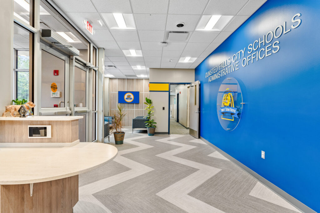 Entrance to the Olmsted Falls City Schools administrative offices, featuring a blue wall with the district seal and signage.