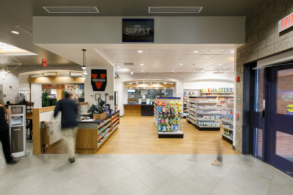 Interior of 1819 Supply store, featuring a service counter, snack aisles, and a University of Virginia banner.