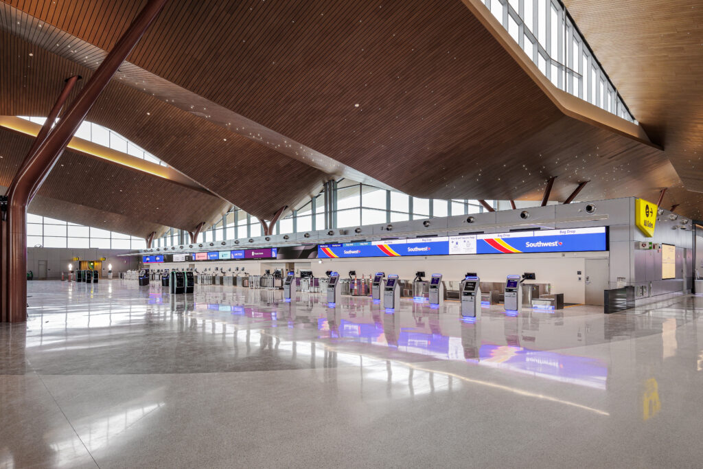 Empty airport check-in area with Southwest Airlines self-service kiosks and signage.