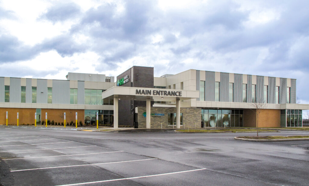 Exterior view of the Main Entrance of the Parkview Cancer Institute with an empty parking lot in the foreground.