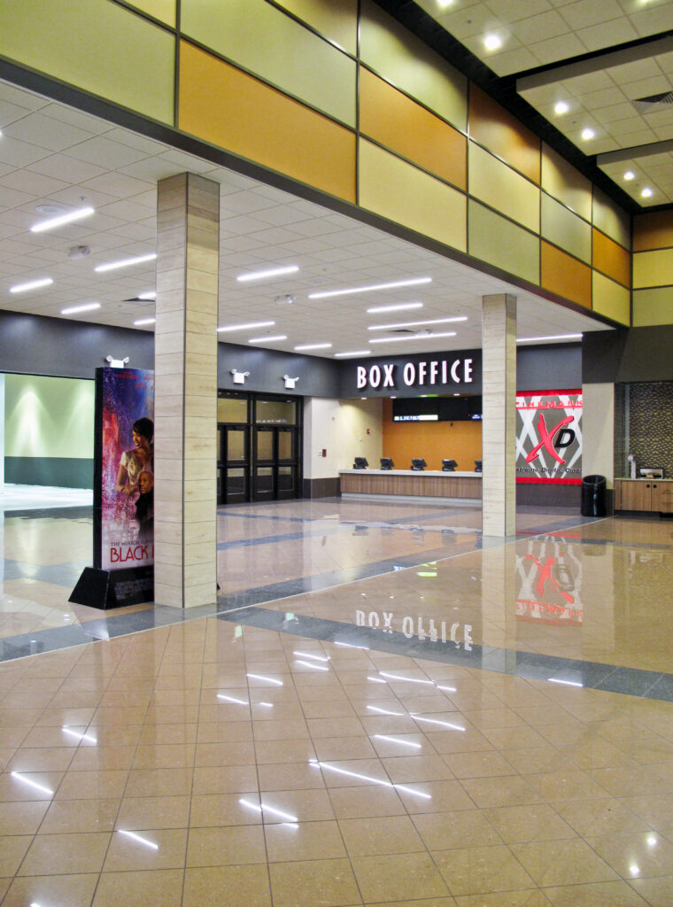 Empty movie theater lobby with a box office counter and a standee for the movie Black Nativity.