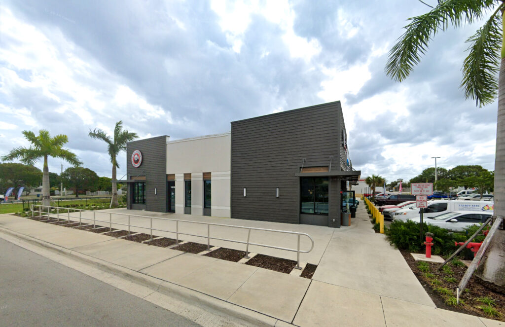 Panda Express restaurant exterior with a sidewalk and parking lot under a cloudy sky.