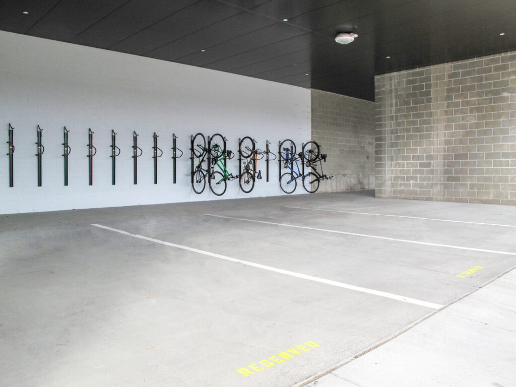 Bicycles mounted on wall racks in an empty concrete parking garage.