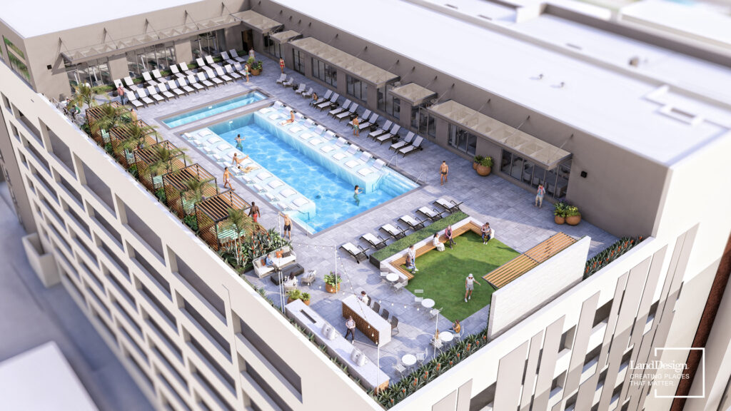 Aerial view of a rooftop terrace with a swimming pool, lounge chairs, a patch of grass, and several people socializing.
