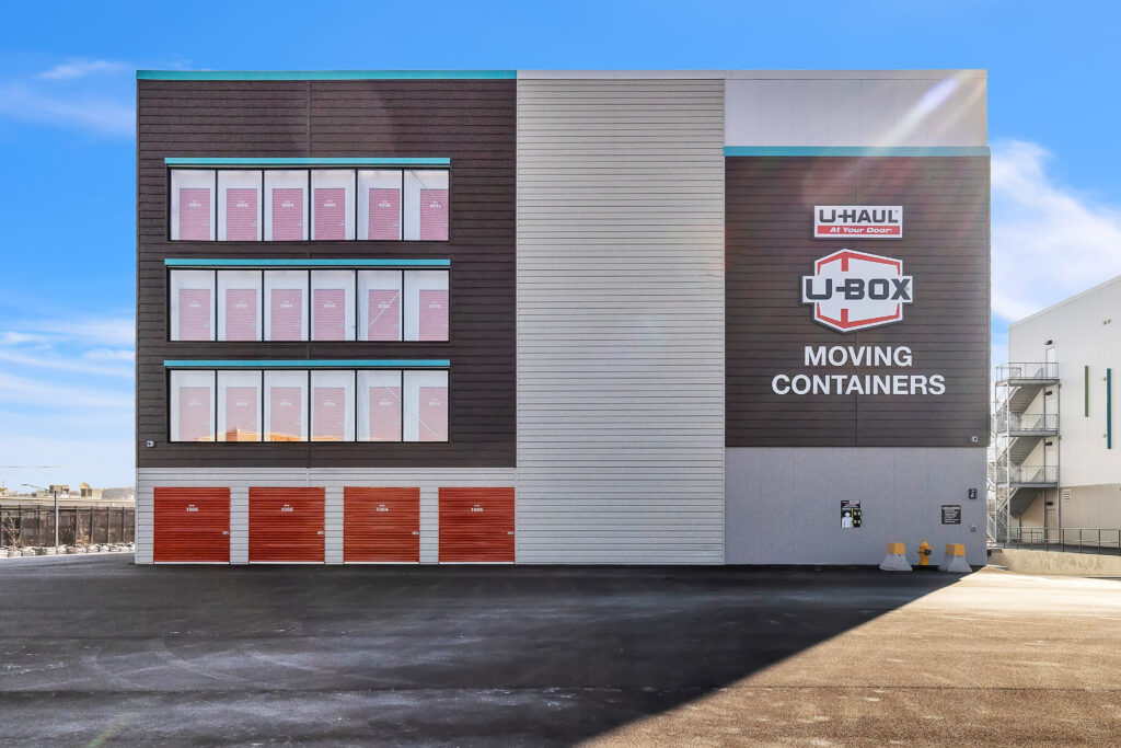 A multi-story U-Haul storage facility featuring exterior storage unit doors and U-Box branding.