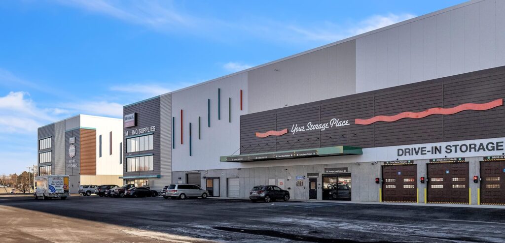 A U-Haul storage facility with multiple drive-in storage bays, a parking lot, and a large sign that reads “Your Storage Place.”