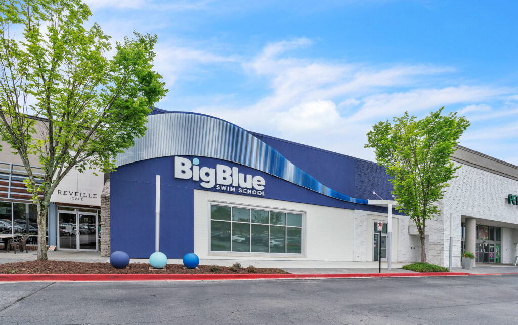 Exterior of a Big Blue Swim School storefront in a shopping center.