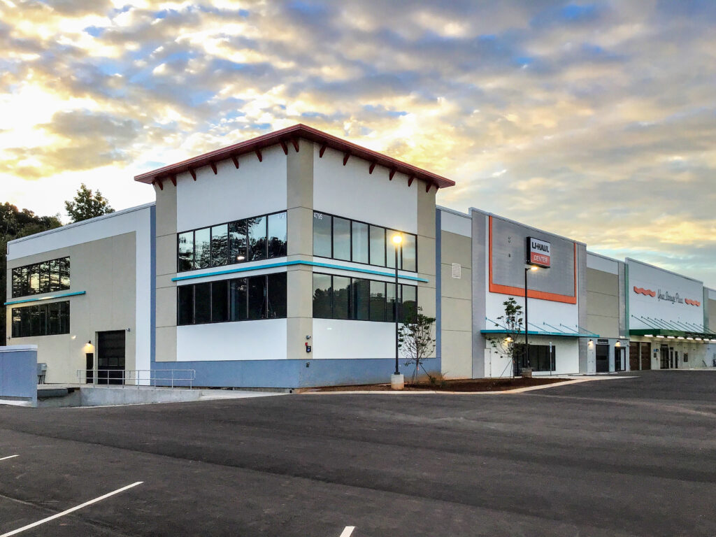 A U-Haul storage center building with a large parking lot under a cloudy sky.