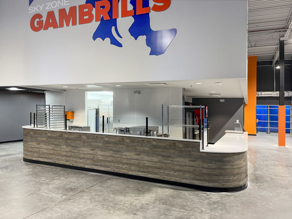 A wood-paneled service counter below a Sky Zone Gambrills sign in an open warehouse space.