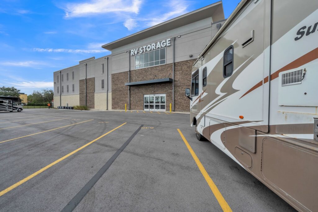 Exterior of an RV storage facility with a recreational vehicle parked in the foreground.