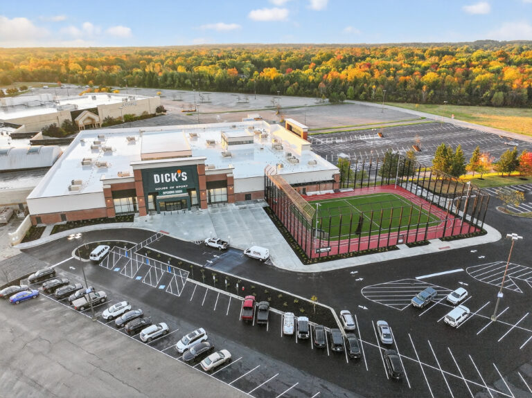 Aerial view of a Dick’s House of Sport store with an outdoor turf field and surrounding parking lots.